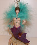 Jonathan was a great party Mardi Gras merman. Feathers and beads make him up for the party he celebrates and he is fabulous!
I have been told by a source that Jonathan, Robbie, and Wave mermen were not Mardi Gras themed, but in fact were supposed to be Las Vegas show guys hence the feather boas. I inquired at December Diamonds about Jonathan and was told he was Mardi Gras themed. Either way, you make the decision.  A great merman and now very rare. 