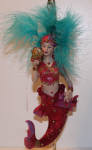 Cerise was one of the many feathered mermaids from 2006. I love the aqua color of her feathers. Although the picture isn't showing this, she is staring at a red jewel in a clam shaped box. She looks mesmerized by it. A beautiful mermaid.