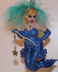  Star is a bizarre mermaid. Star has eyes as stars holding a string with stars on it.  This could remind me of some New York art gallery version of December Diamonds. Original yes! She is one of a kind. Maybe a costume party mermaid for all the non-arty folks to think about.